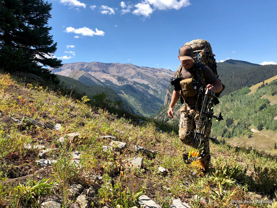 Man bowhunting in mountains with pack, bow and camouflage. Man bowhunting in mountains with pack, bow and camouflage.