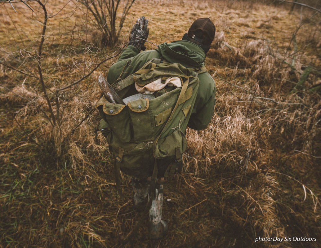 Man with backpack hiking and hunting as he sets up traps in the woods in the fall. Man with backpack hiking and hunting as he sets up traps in the woods in the fall.