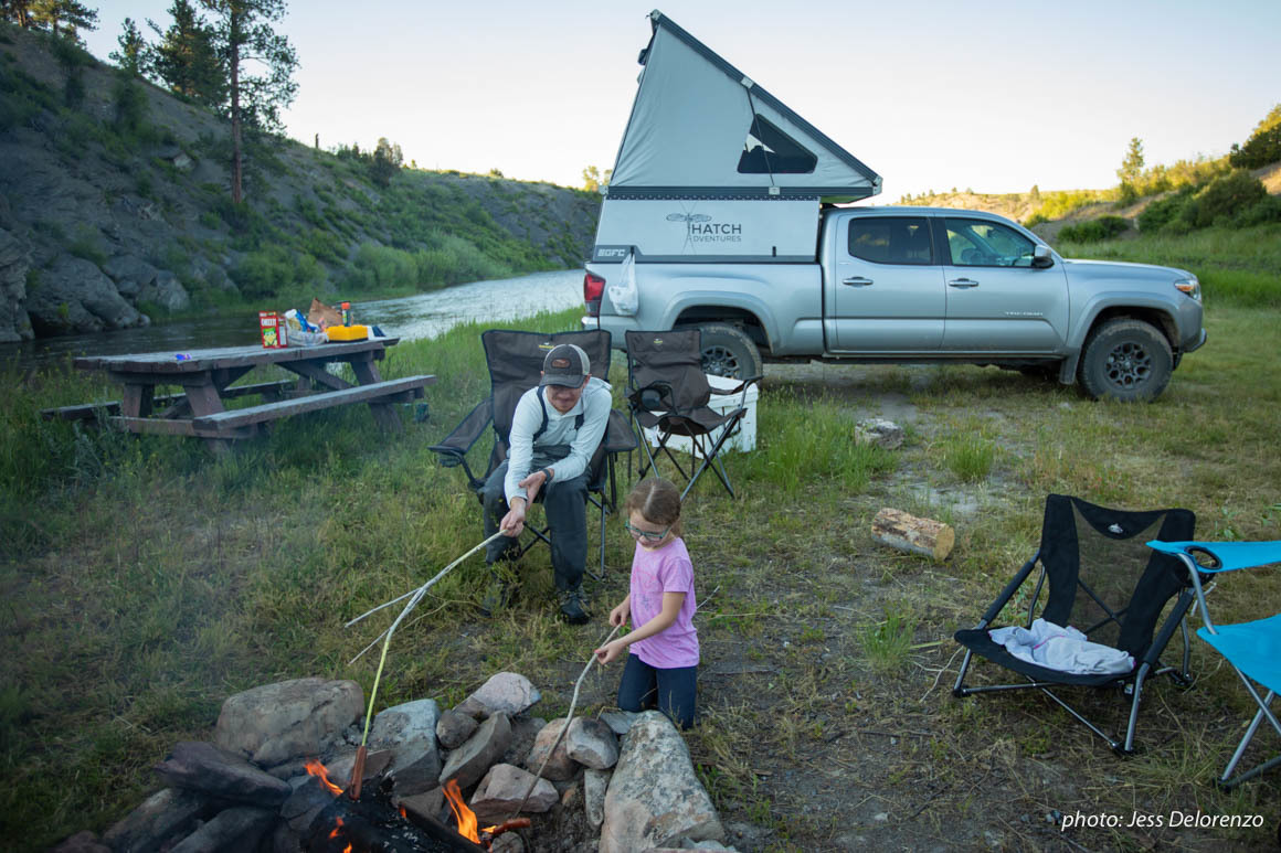 Father and daughter at campfire while truck camping in Montana. Father and daughter at campfire while truck camping in Montana.