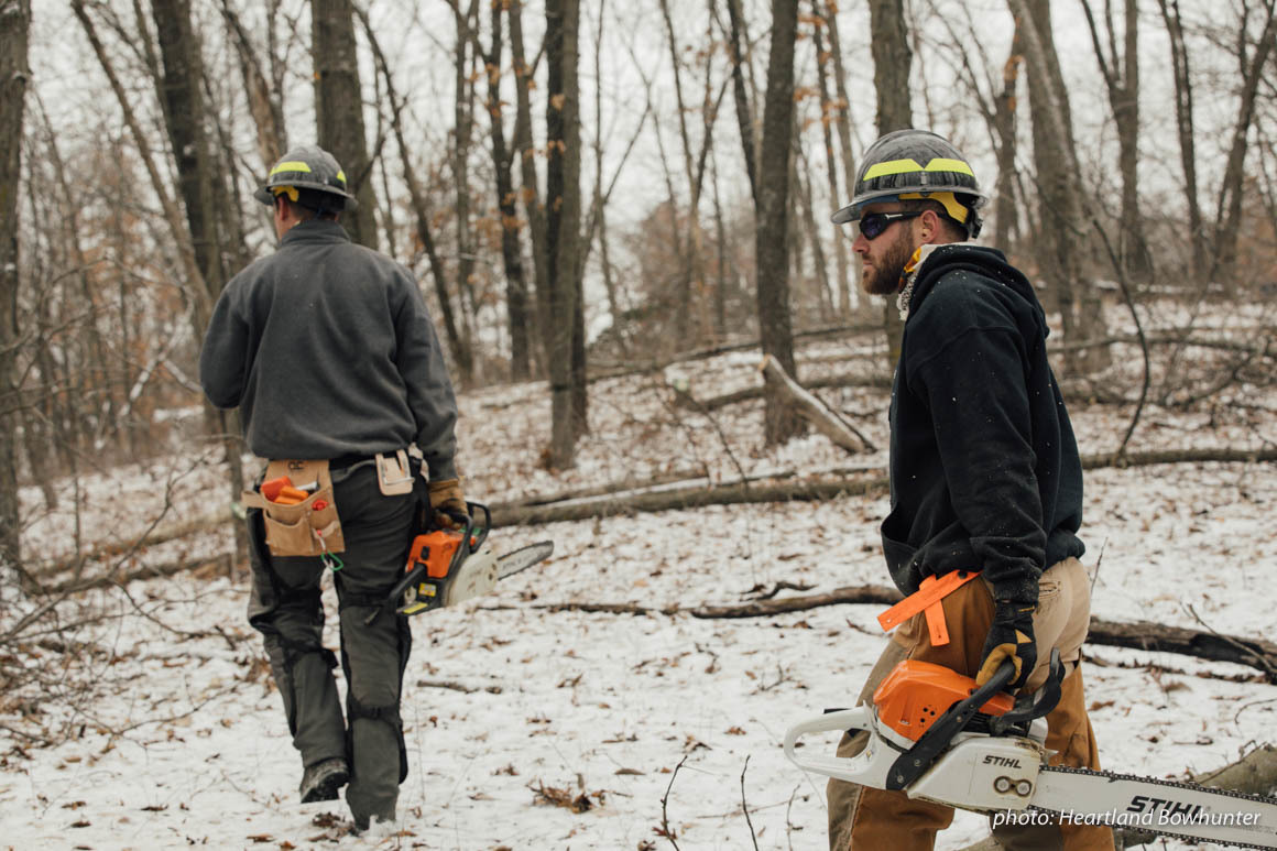 Two men with chainsaws work in snowy woods. Two men with chainsaws work in snowy woods.