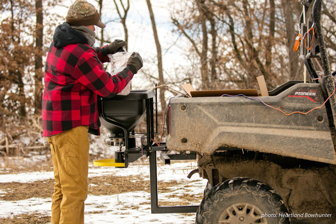 Man loads seed into an ATV in the wintertime. Man loads seed into an ATV in the wintertime.