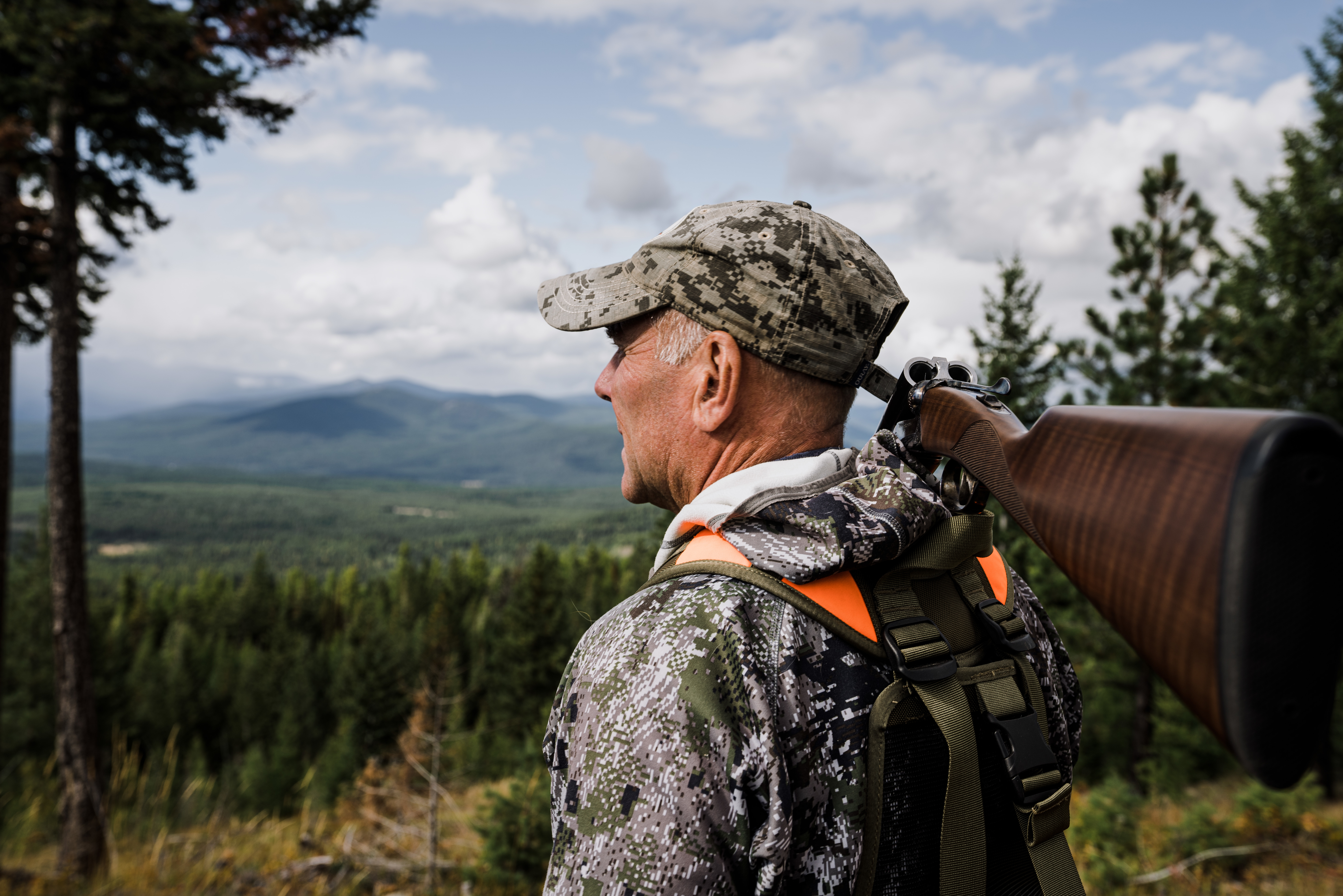 Montana outfitter Tim Linehan holds a shotgun and looks out over the valley. Montana outfitter Tim Linehan holds a shotgun and looks out over the valley.