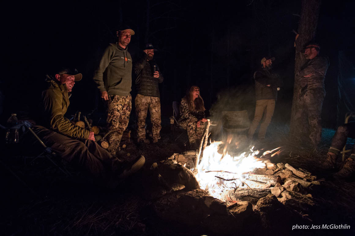 Men and women gathered around a campfire while hunting in Montana. Men and women gathered around a campfire while hunting in Montana.
