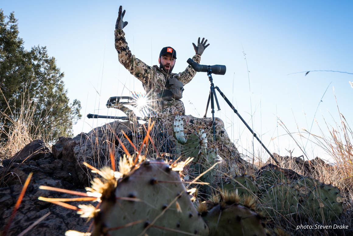 Hunter in camo excited while looking through scope, hunting in Arizona for mule deer. Hunter in camo excited while looking through scope, hunting in Arizona for mule deer.