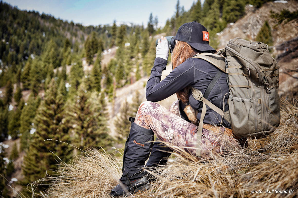 Woman in camouflage glassing for animals while hunting in the mountains. Woman in camouflage glassing for animals while hunting in the mountains.