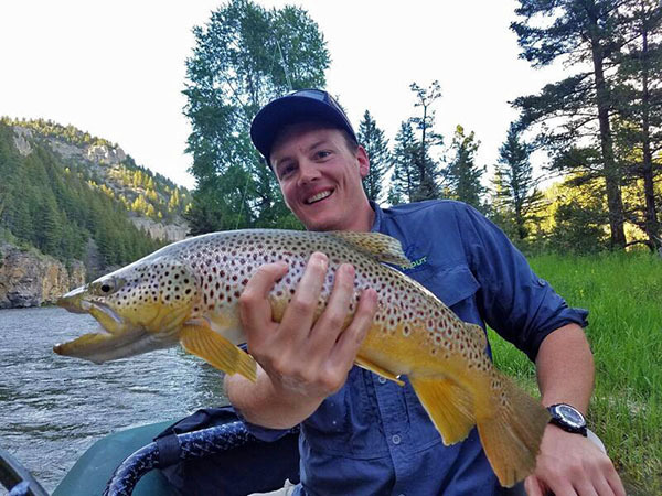 Man holding large brown trout caught while fly fishing on Montana's Smith River. Man holding large brown trout caught while fly fishing on Montana's Smith River.