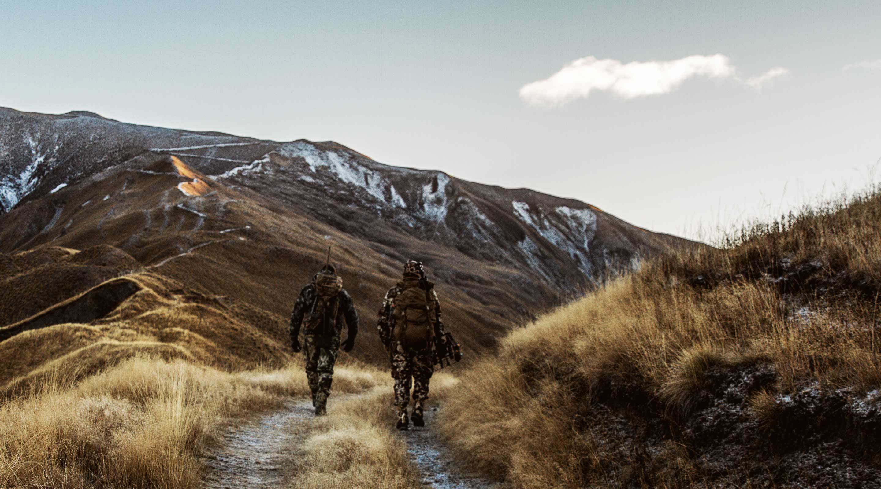 Two men in camouflage walk into the mountains in morning to hunt. Two men in camouflage walk into the mountains in morning to hunt.