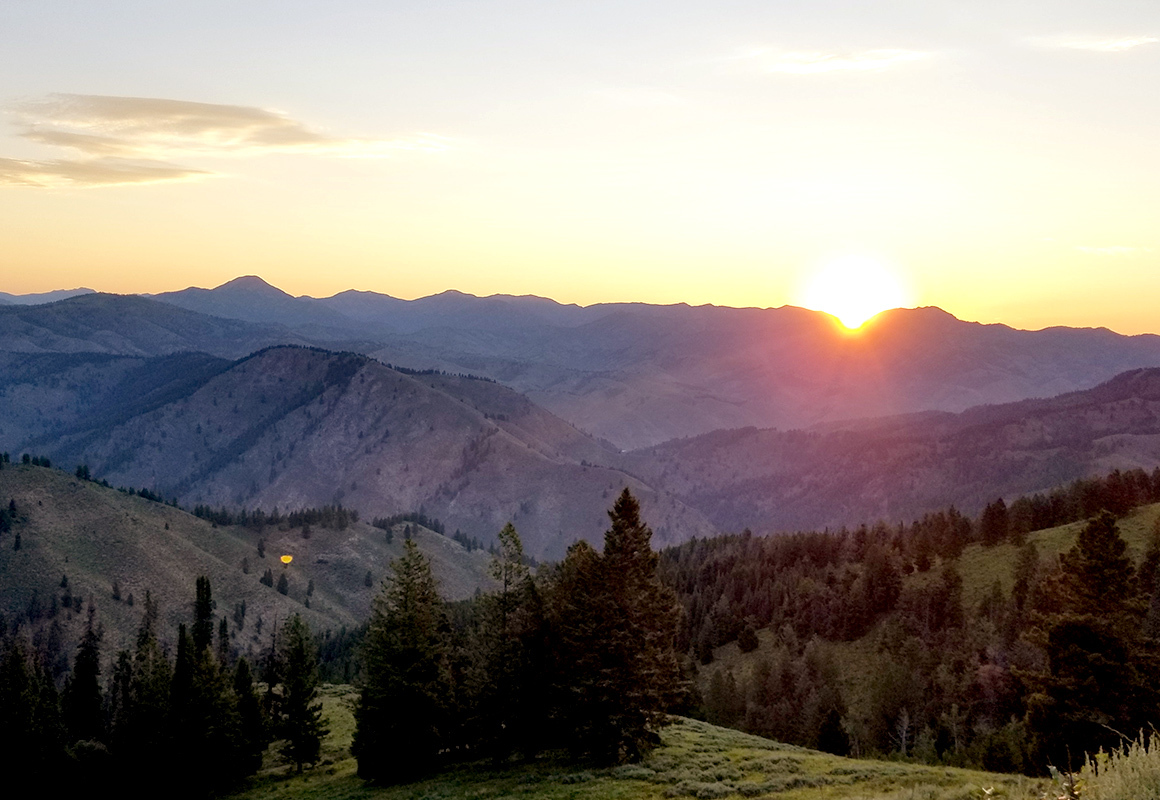 A wilderness sunset in the mountains, as the sun sets below the horizon. A wilderness sunset in the mountains, as the sun sets below the horizon.