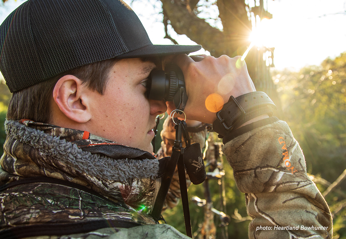 Man looking through binoculars while hunting whitetail deer. Man looking through binoculars while hunting whitetail deer.
