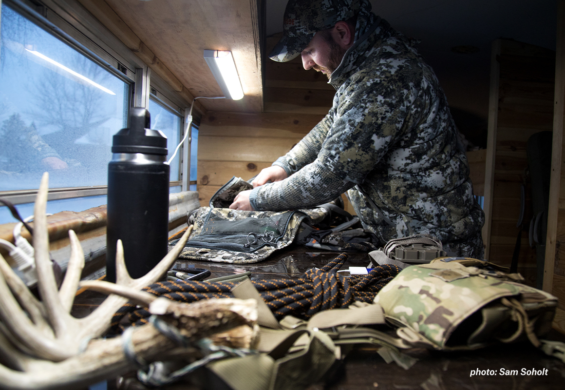 Man preparing and loading gear before heading outside to hunt. Man preparing and loading gear before heading outside to hunt.